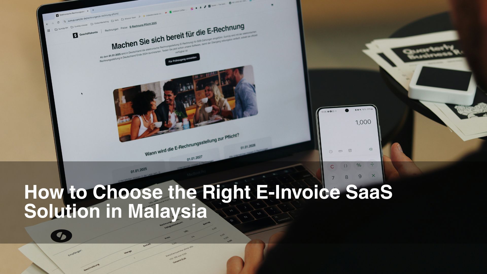 Man holding phone in front of einvoice laptop